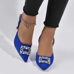 Close-up of royal blue pointed-toe heels with sparkling crystal square buckle