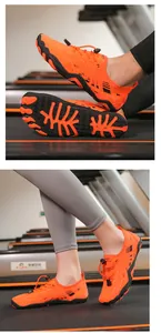Detail van oranje waterschoenen met antislipzool en mesh bovenwerk op een loopband