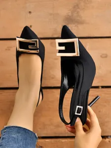 Elegant black pointed-toe slingback heels with a large gold G-shaped metal buckle detail.