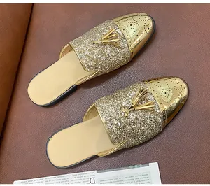 Detailansicht goldener Herren-Slipper mit Glitzer und eleganter Quastenverzierung