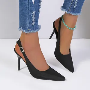 Vista detallada de elegantes tacones negros de punta con correa trasera y tacón fino