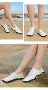 Meerdere aanzichten van witte en neongroene sneldrogende waterschoenen op een zandstrand.