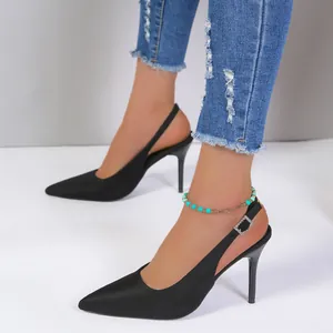 Elegantes sandalias negras de tacón alto con punta fina mostradas en una modelo