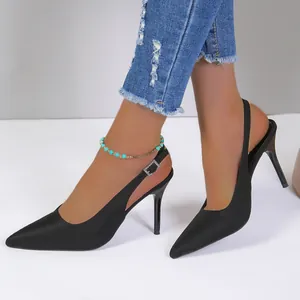 Vista lateral detallada de elegantes zapatos negros de tacón fino con punta en modelo