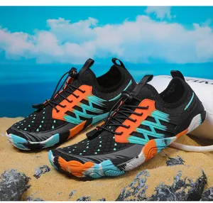 Gedetailleerd overzicht van zwarte en oranje waterschoenen voor snorkelen op het strand