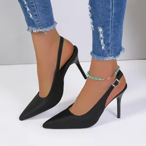 Primer plano de elegantes zapatos de salón negros con tacón de aguja y vaqueros de moda