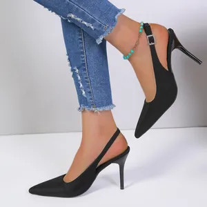 Primer plano de elegantes tacones de aguja negros con punta fina y hebilla de pedrería