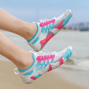 Ademende mesh waterschoenen met roze accenten op een zonnig strand op de achtergrond