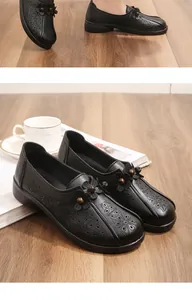 Comfortable black leather loafers for elderly women with laser-cut floral details
