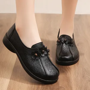 Comfortable black leather hollow-out flat shoes for middle-aged women with floral decor.