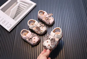 Detailansicht niedlicher Baby-Mädchen-Sandalen mit karierter Schleife und Stickerei