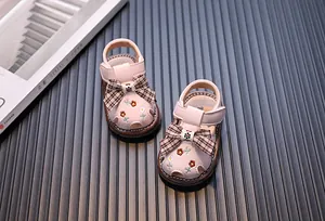 Detailansicht von rosa Lauflern-Sandalen mit Schleife und Blumenstickerei für kleine Babys.