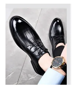 Close-up view of black breathable leather dress shoes with elegant laser-cut perforations