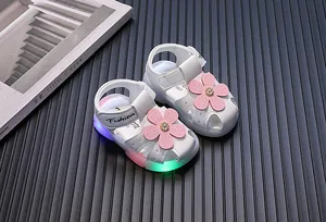 Detailansicht weißer Babysandalen für Mädchen mit rosa Blume und leuchtenden LED-Sohlen