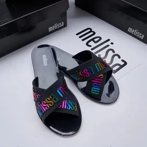 Close-up of Melissa jelly sandals featuring holographic logo lettering on cross straps