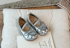 Dettaglio di scarpe Mary Jane argento metallizzato per bambina con fiocco