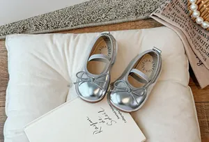 Vista dettagliata di scarpe Mary Jane argentate per bambina con un grazioso fiocco