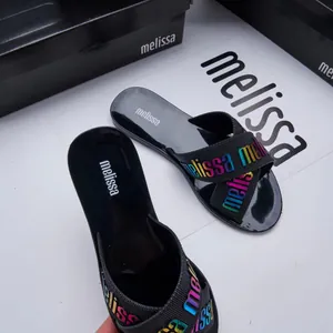 Close-up of Melissa black jelly sandals with colorful cross straps and logo detail.