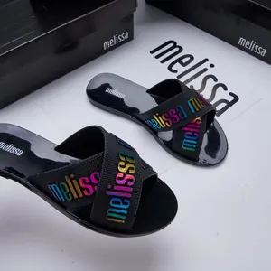 Black Melissa jelly cross-strap slippers with vibrant rainbow logo lettering detail