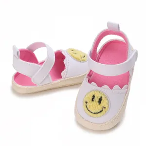 Dettaglio di scarpine primi passi per neonati con suola morbida e toppa con smiley