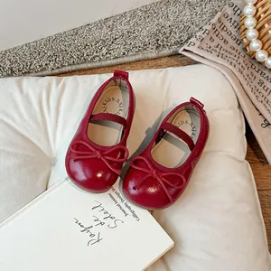 Scarpe Mary Jane rosse per bambine con grazioso fiocco su un morbido cuscino bianco