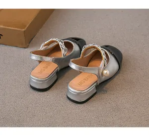 Detailed back view of girls silver and black sandals with pearl and chain decoration