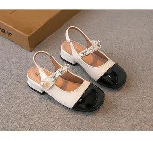 Detailed view of girls' elegant beige and black color-block sandals with pearl chain