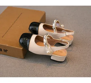 Close-up of girls' pearl chain sandals with classic black cap toe and beige leather.