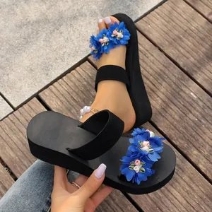 Detailed view of women's thick-sole wedge sandals featuring vibrant blue fabric flower accents
