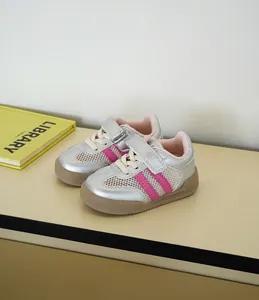 Vista detallada de zapatillas de malla para bebé con acabado plateado y rayas rosas