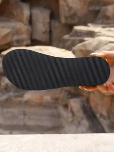 Detailed macro view of the black anti-slip ribbed sole on a platform slipper.