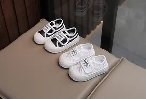 Vue détaillée des baskets respirantes en maille creuse pour enfants en noir et blanc
