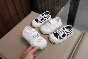 Vue détaillée des baskets respirantes en maille creuse pour enfants en blanc et noir
