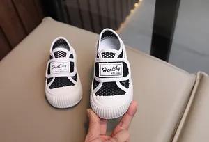 Détail de chaussures en maille respirante pour enfants avec velcro et semelles blanches