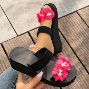 Women's platform beach sandals featuring vibrant pink flower decorations and wedge heels.