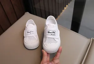 Vue détaillée de la texture en maille blanche de ces baskets en toile pour enfants
