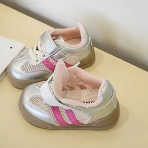 Detalle de zapatillas de malla plateada transpirable para niños pequeños con rayas rosas