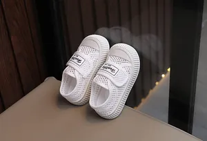 Gros plan de baskets en maille blanche respirante pour enfants avec velcro