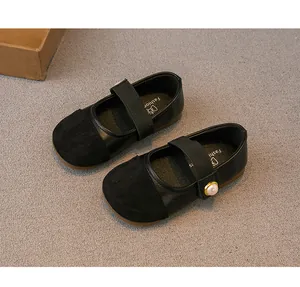 Elegant black girl's Mary Jane flats featuring a pearl button strap and suede toe cap