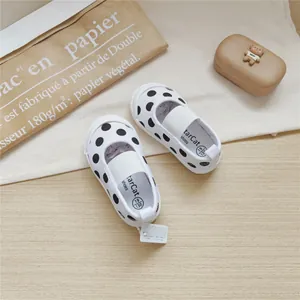 Top view of children's polka dot canvas shoes with elastic straps for toddlers