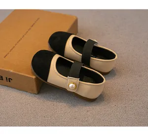 Elegant beige and black girls Mary Jane shoes featuring a decorative pearl button