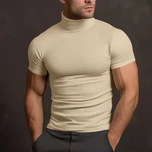 Dettaglio della vestibilità aderente e del collo alto della t-shirt beige a maniche corte