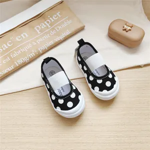 Detailed view of black and white polka dot canvas shoes for girls with elastic strap