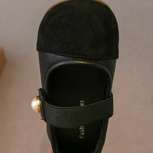Classic black Mary Jane shoes for girls featuring a pearl elastic strap and suede toe cap