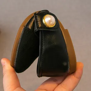 Flexible black Mary Jane shoes for girls featuring elegant pearl and gold detail