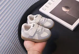 Close-up view of stylish toddler walking shoes featuring velcro straps and grey accents