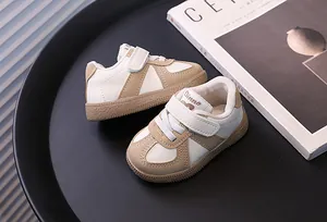 Detailed view of stylish beige and white toddler walking shoes presented on a black tray