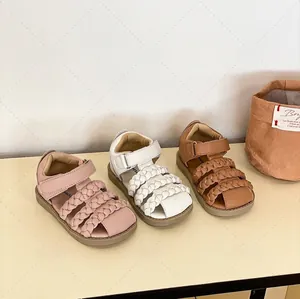 Λεπτομερής προβολή πλεκτών σανδαλιών για κοριτσάκια σε ροζ, λευκό και καφέ χρώμα