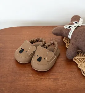 Detailed view of brown infant walking shoes featuring a cute koala face and elastic heel strap