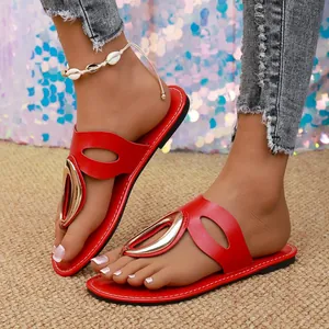 Close-up of stylish red flat sandals with gold metal buckle decoration for women